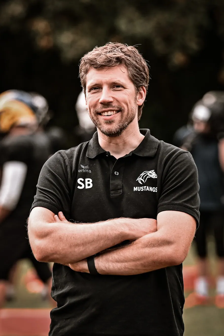 Dr. Stephan Bartsch im Poloshirt der Mustangs am Spielfeldrand